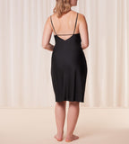 Back view of model wearing the Triumph Silky Sensuality black nightdress, highlighting the lace-trimmed neckline and fluid, shimmering fabric. Available for Online Purchase