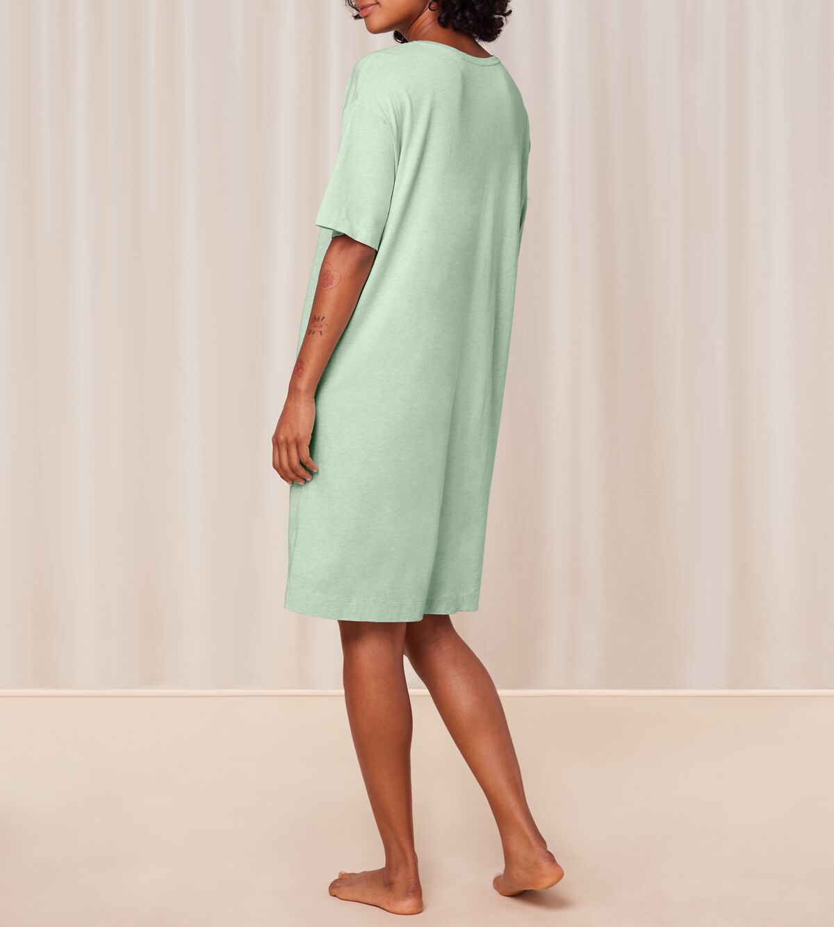 Back view of model wearing the Triumph green short sleeve nightdress, highlighting the relaxed silhouette and soft-touch fabric. Shop the Latest Online