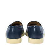 Rear view of a pair of Baldinini navy loafers, showing the clean grained leather heel counter seams and the flat, supportive profile of the cream-beige rubber sole against a white background.