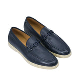 An overhead three-quarter perspective of a pair of Baldinini navy driving loafers, displaying the soft pebbled leather texture and the tonal matte logo bridge strap details against a white background.