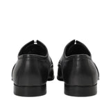 Rear view of a pair of Baldinini black Derby shoes displaying the sturdy, structured leather heel counters and clean, low-profile black block heels against a white background.