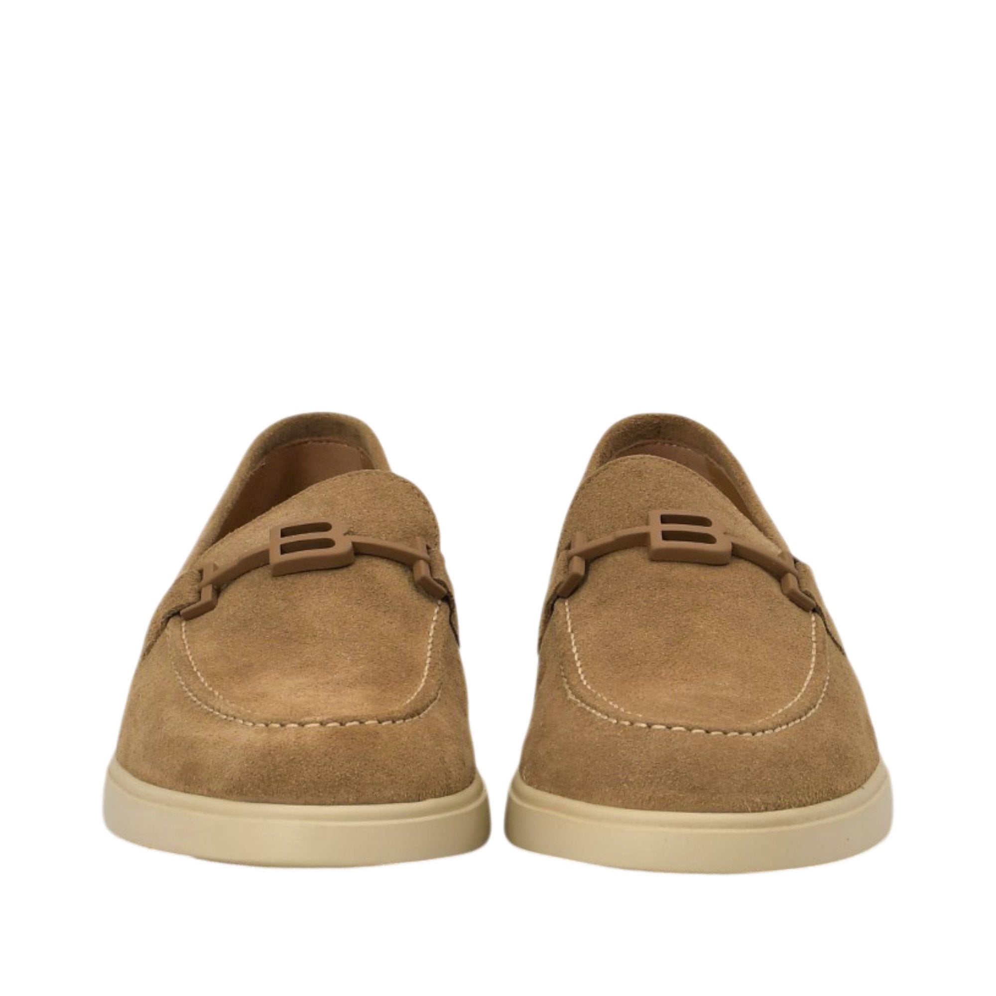 Front-facing view of a pair of Baldinini tan suede loafers showcasing the contrast cream topstitching on the apron toe and the integrated 'B' logo strap across the vamps against a white background.