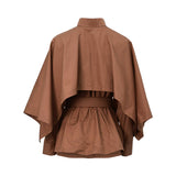 Back view of the BAQA cape-detail shirt showing the structured drape of the overlay and the cinched belted waist.
