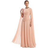 A woman modeling a floor-length peach chiffon gown with draped one-shoulder sleeves, a ruched waist, and a sheer draped overlay, set against a plain white background.