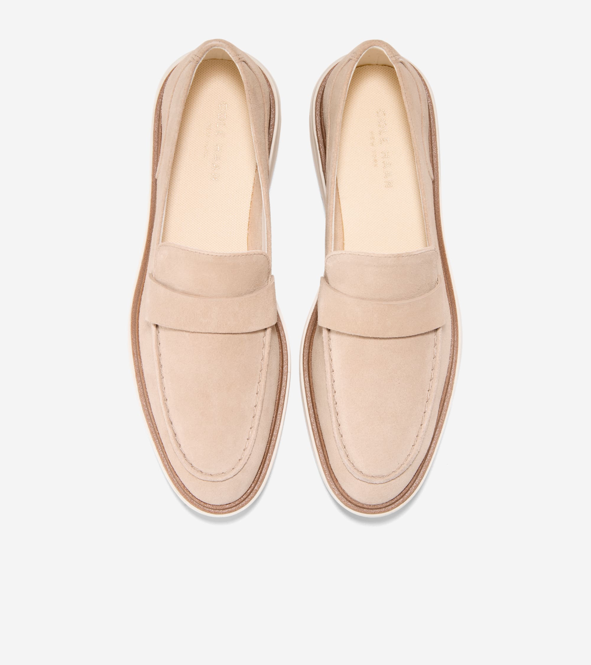 Pair of light beige suede penny loafers with white soles and light brown trim. Visible stitching around the toe box.