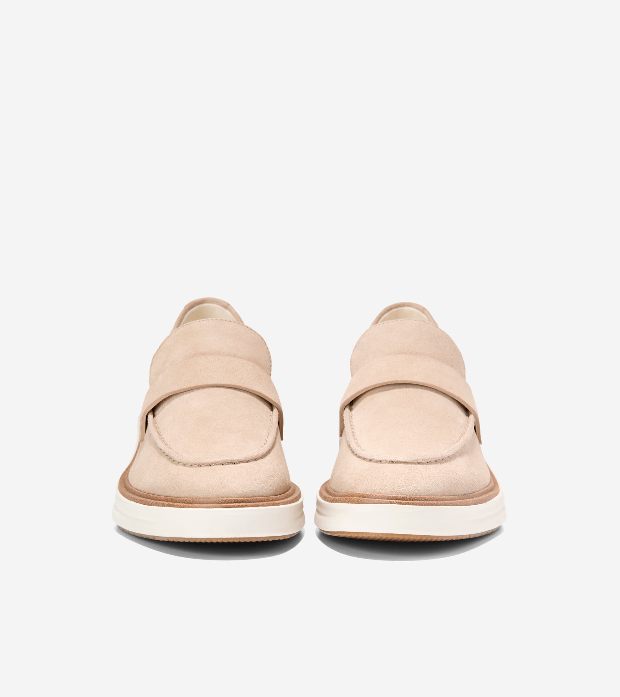 Pair of nude suede loafers with a strap across the vamp, visible stitching, and a thick white sole with brown trim.