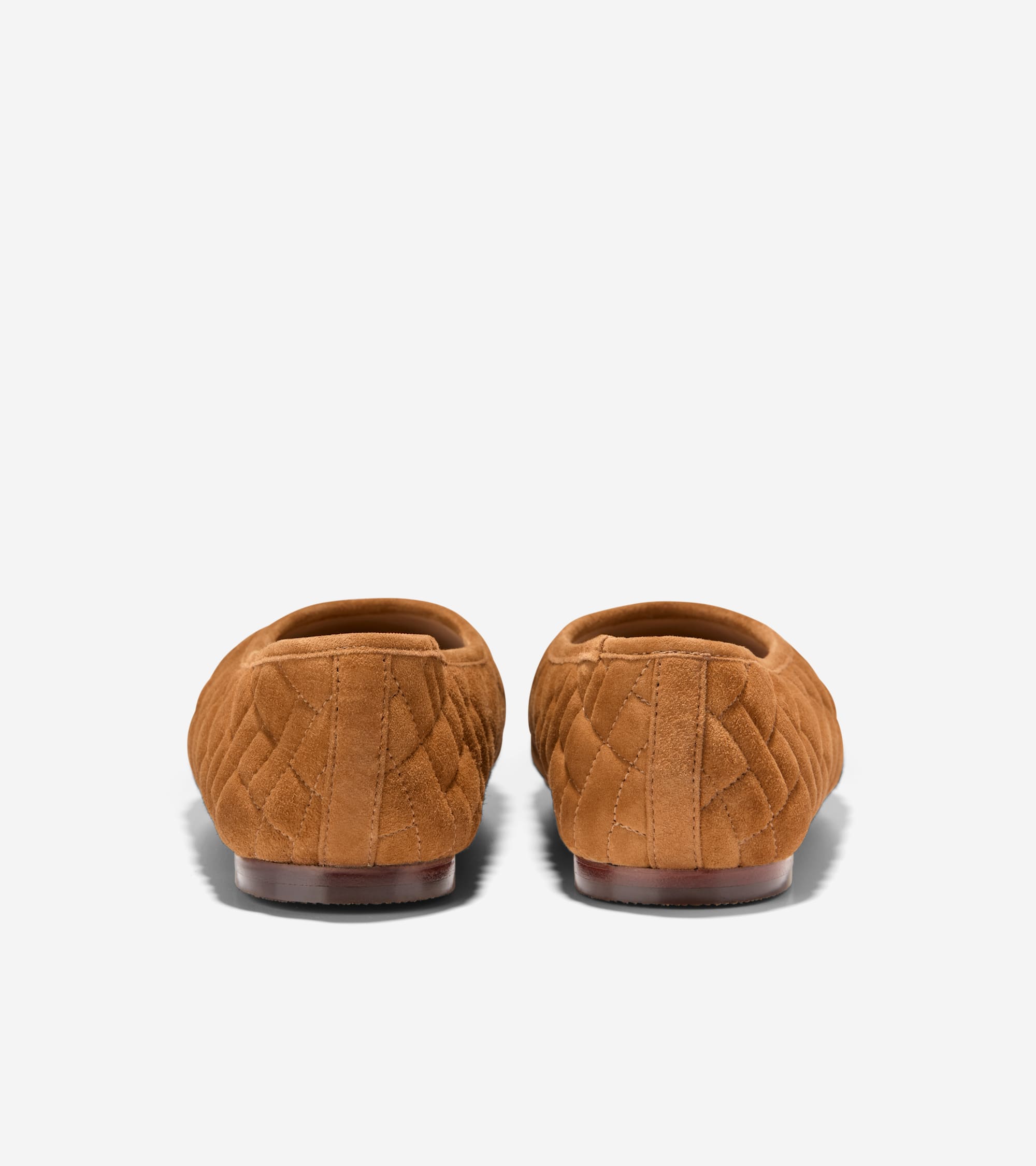 Brown suede ballet flats with diamond quilting, seen from the back, showing dark brown soles.