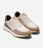 Off-white leather sneakers with tan suede toe and side accents, dark brown heel, and white laces. Perforated details, white m