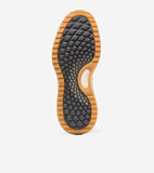 Bottom of a golf shoe sole with a ridged tan outer edge and a dark gray textured center. A tan oval insert reads 'COLE HAAN'.