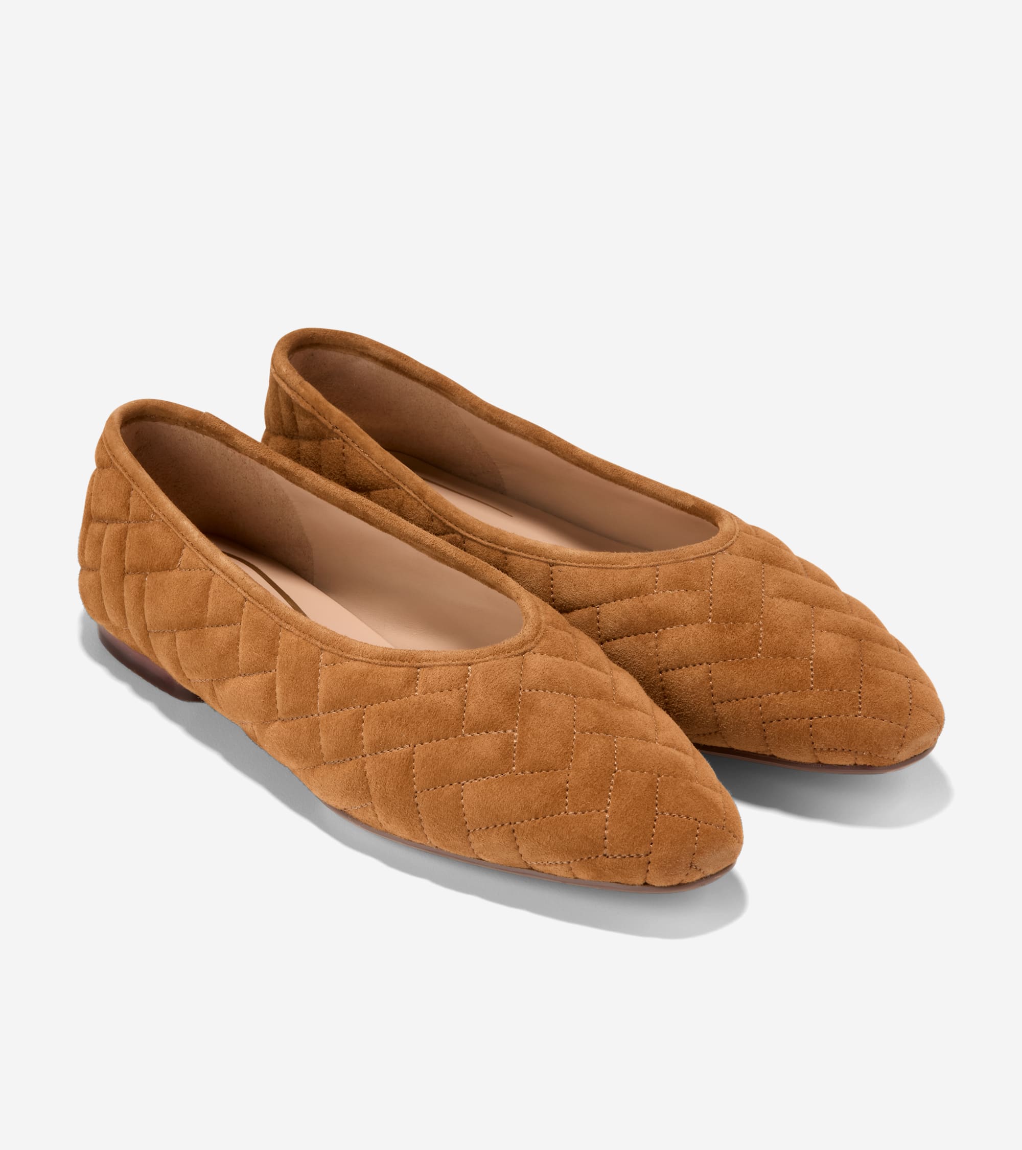 Pair of brown suede ballet flats with a chevron quilted pattern. Dark brown sole visible on the left shoe.
