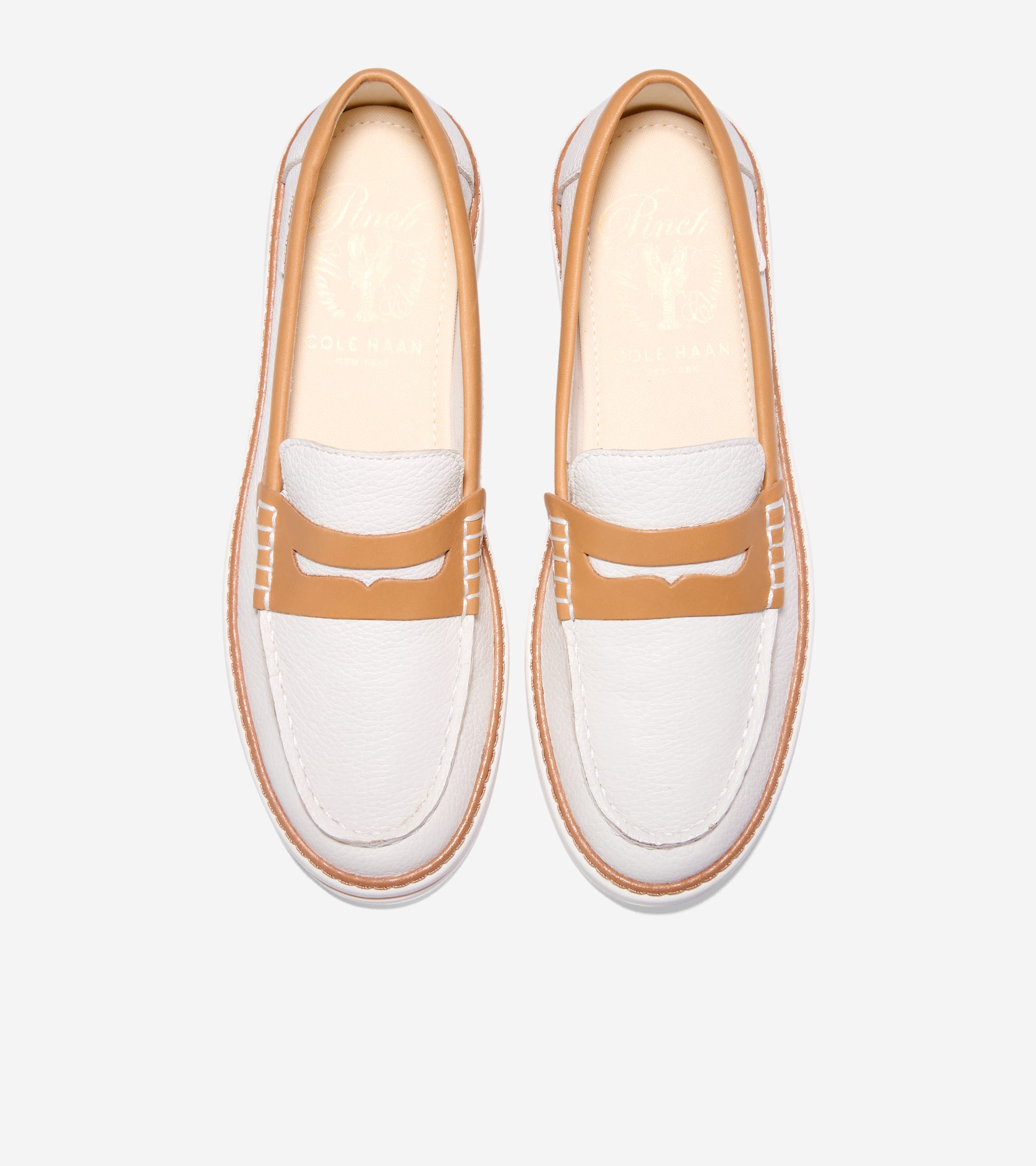 Pair of white textured leather penny loafers with tan trim, tan penny straps, and white soles. Gold-toned logo on insole.