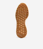 Sneaker with a light tan sole featuring a diamond-patterned tread. The brand name 'Cole Haan' is visible on the heel.