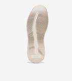 Cream-colored shoe sole with horizontal ribbing and a central vertical groove. 'COLE HAAN ZERØGRAND' is embossed near the hee