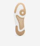White sneaker sole with tan rubber sections: wavy toe, honeycomb midfoot, circular pivot, and textured heel with 'COLE HAAN'