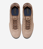 Pair of light brown suede sneakers with dark brown laces, mesh tongue, and heel trim. White stitching details and blue insole