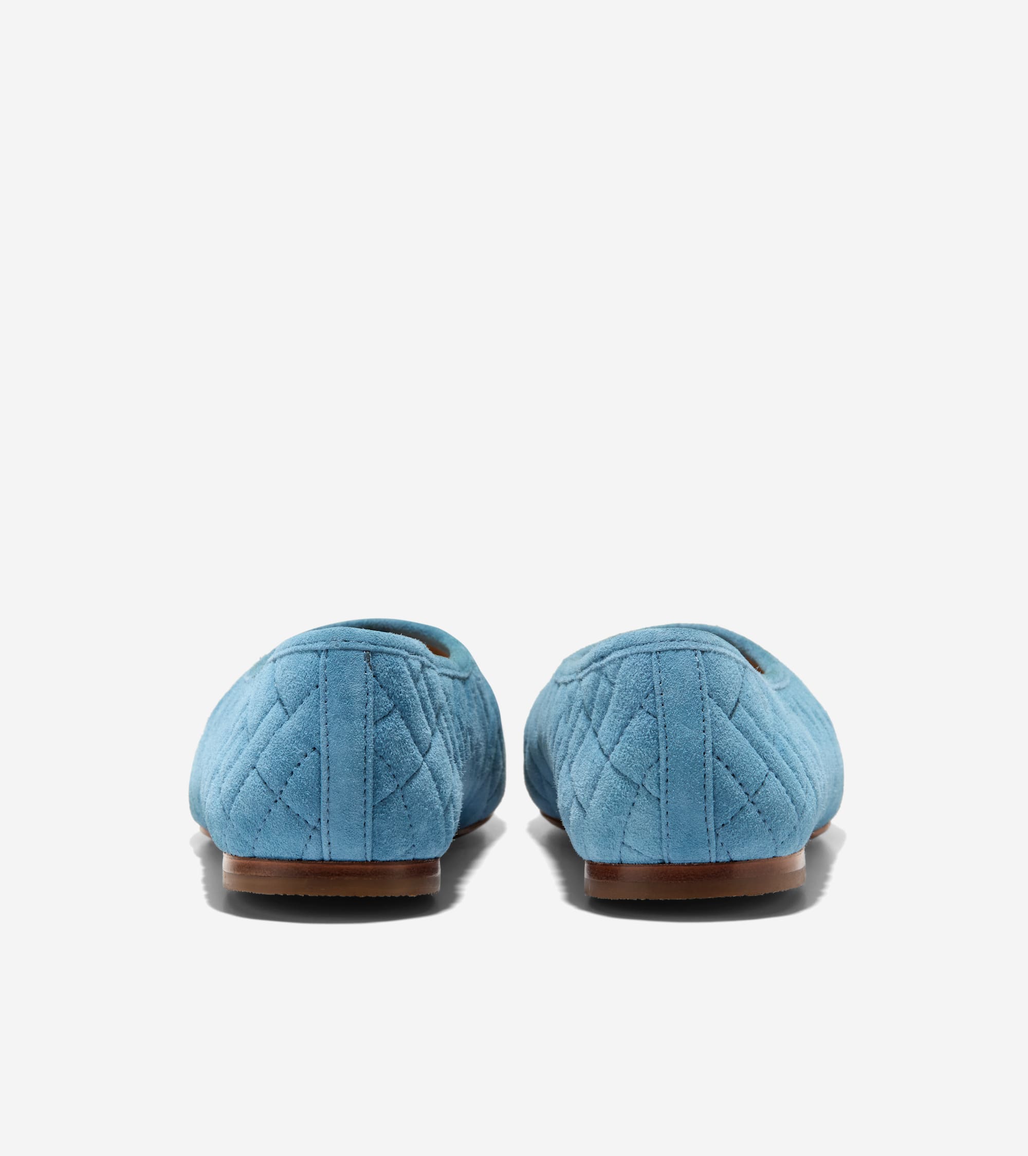 Back view of light blue quilted ballet flats with brown flat soles.