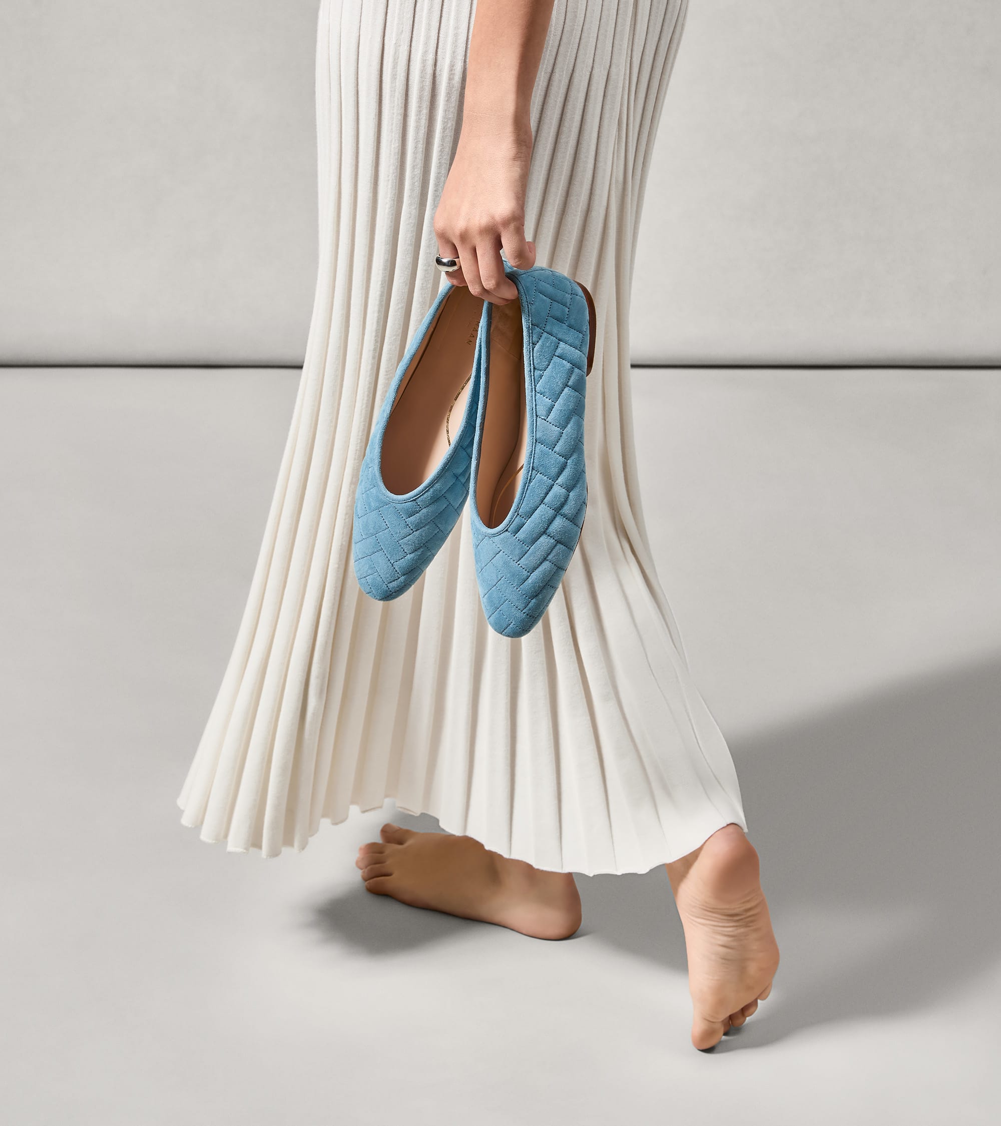 Light blue ballet flats with a diagonal quilted pattern. They have light brown soles and tan interior lining.