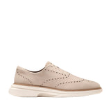 Light beige nubuck men's wingtip oxfords with brogue detailing and a thick white sole.