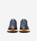 Navy blue leather slip-on sneakers with matching laces, white midsoles, and brown rubber outsoles featuring a diamond pattern