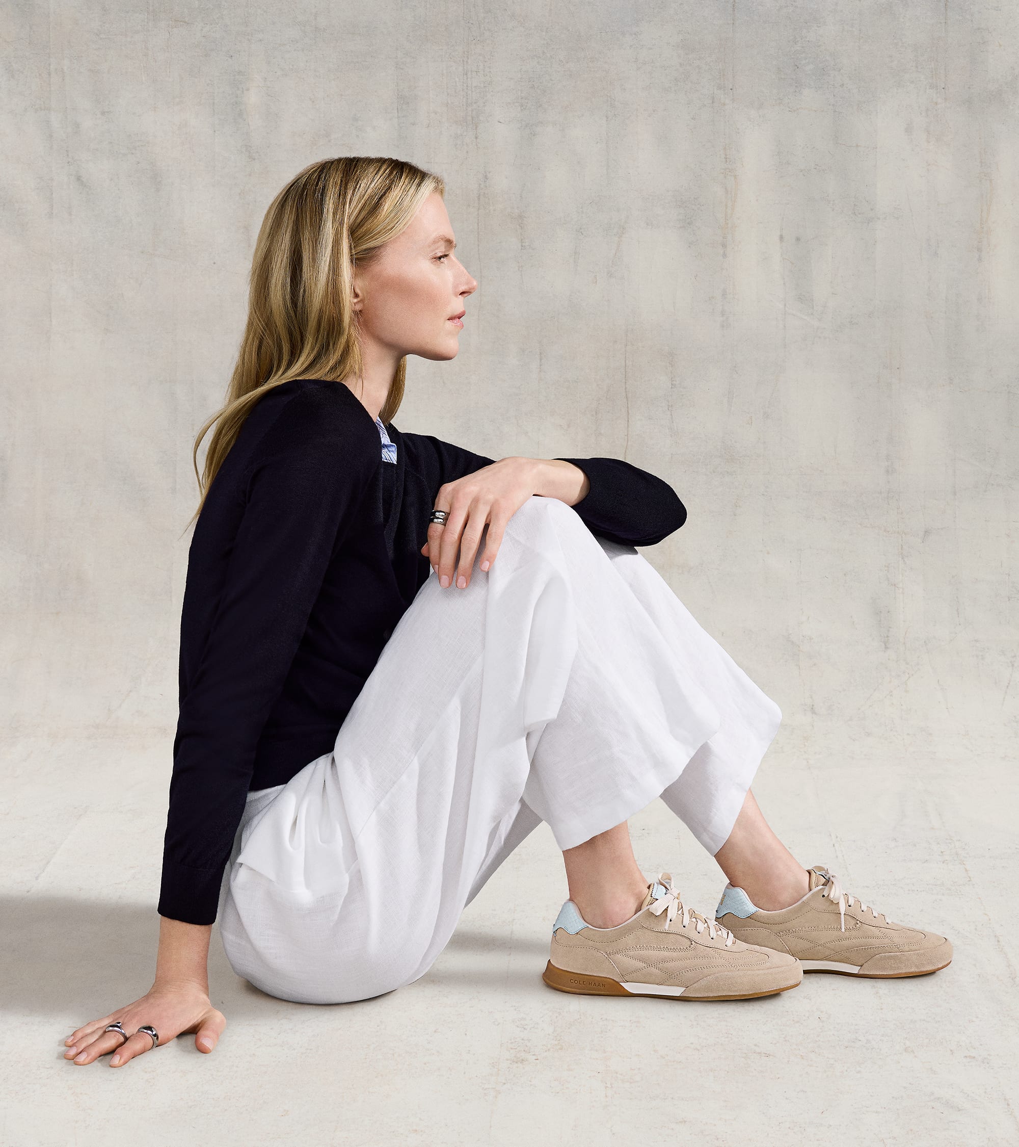 Tan suede sneakers with white laces, light blue heel accents, and a white midsole with a tan outsole.