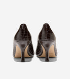 Pair of dark brown, glossy, crocodile-embossed pumps with medium heels, seen from the back, revealing light tan soles.