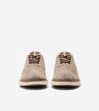 Pair of tan knit wingtip oxfords with brown laces, brown trim, and a cream and brown sole.