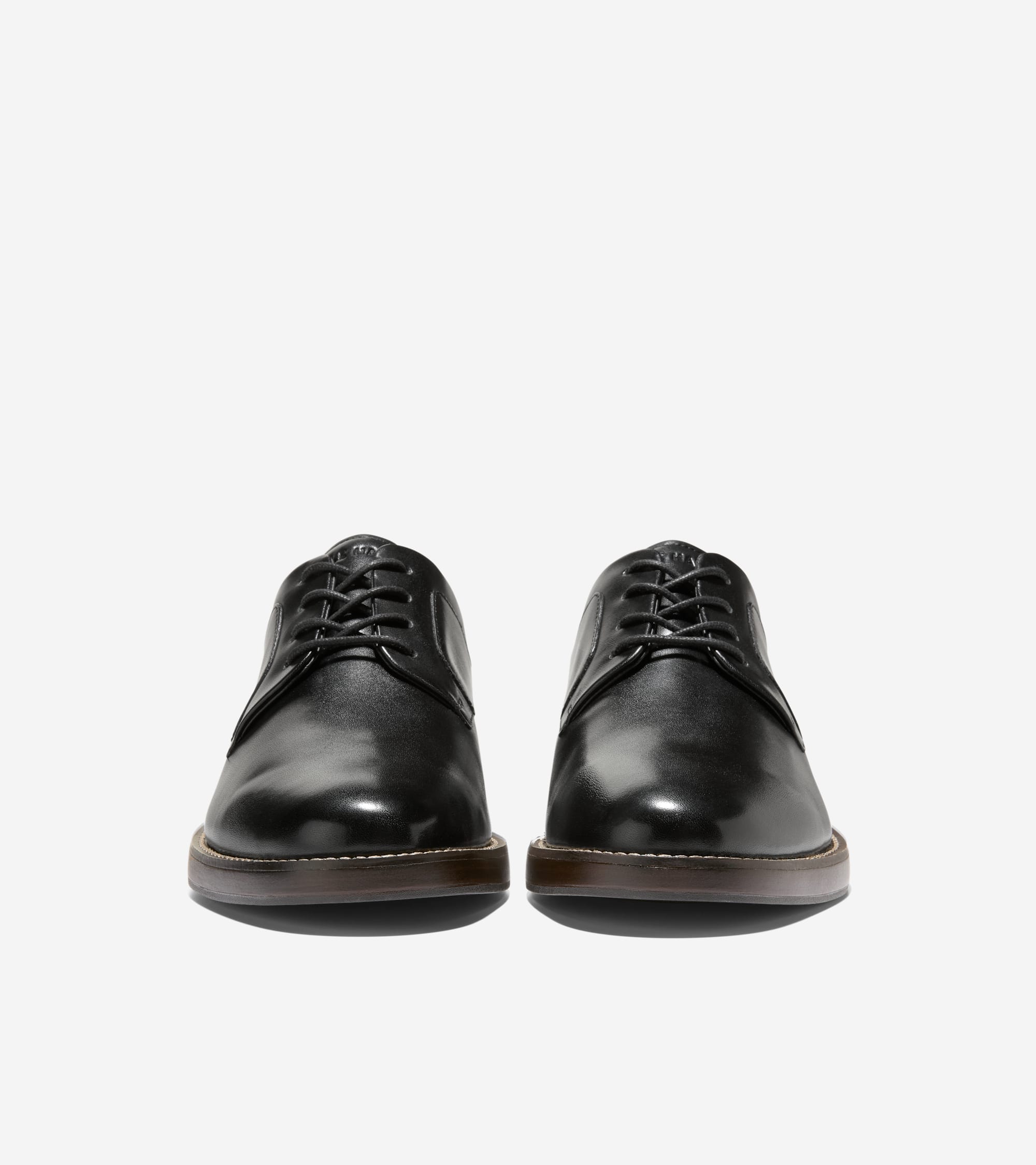 Pair of black plain-toe leather Oxfords with black laces, dark brown soles, and light welt stitching.