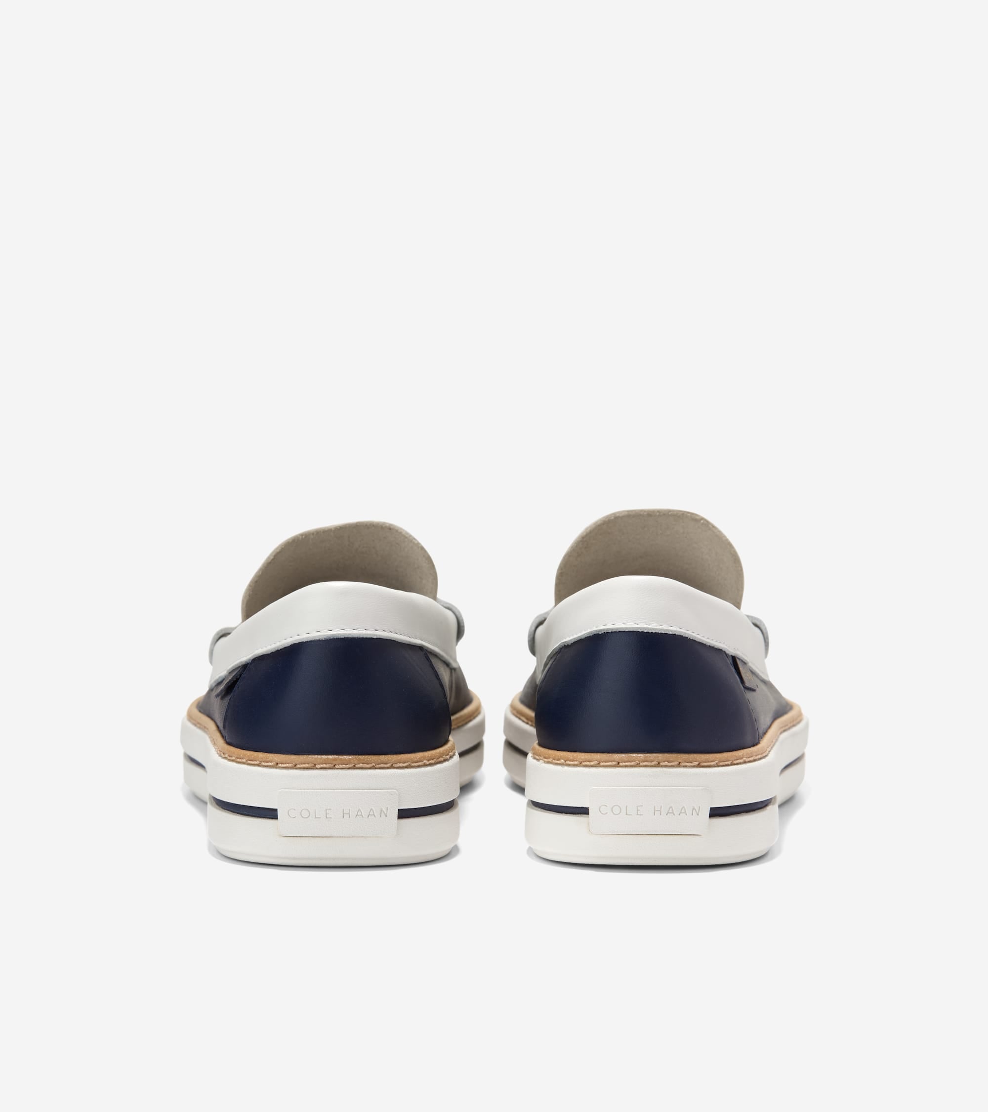 Pair of navy blue leather loafers with white leather collars, light brown trim, and thick white soles with navy stripes and "
