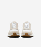 Pair of off-white and tan suede slip-on sneakers with white decorative laces, white midsoles, and brown textured outsoles.