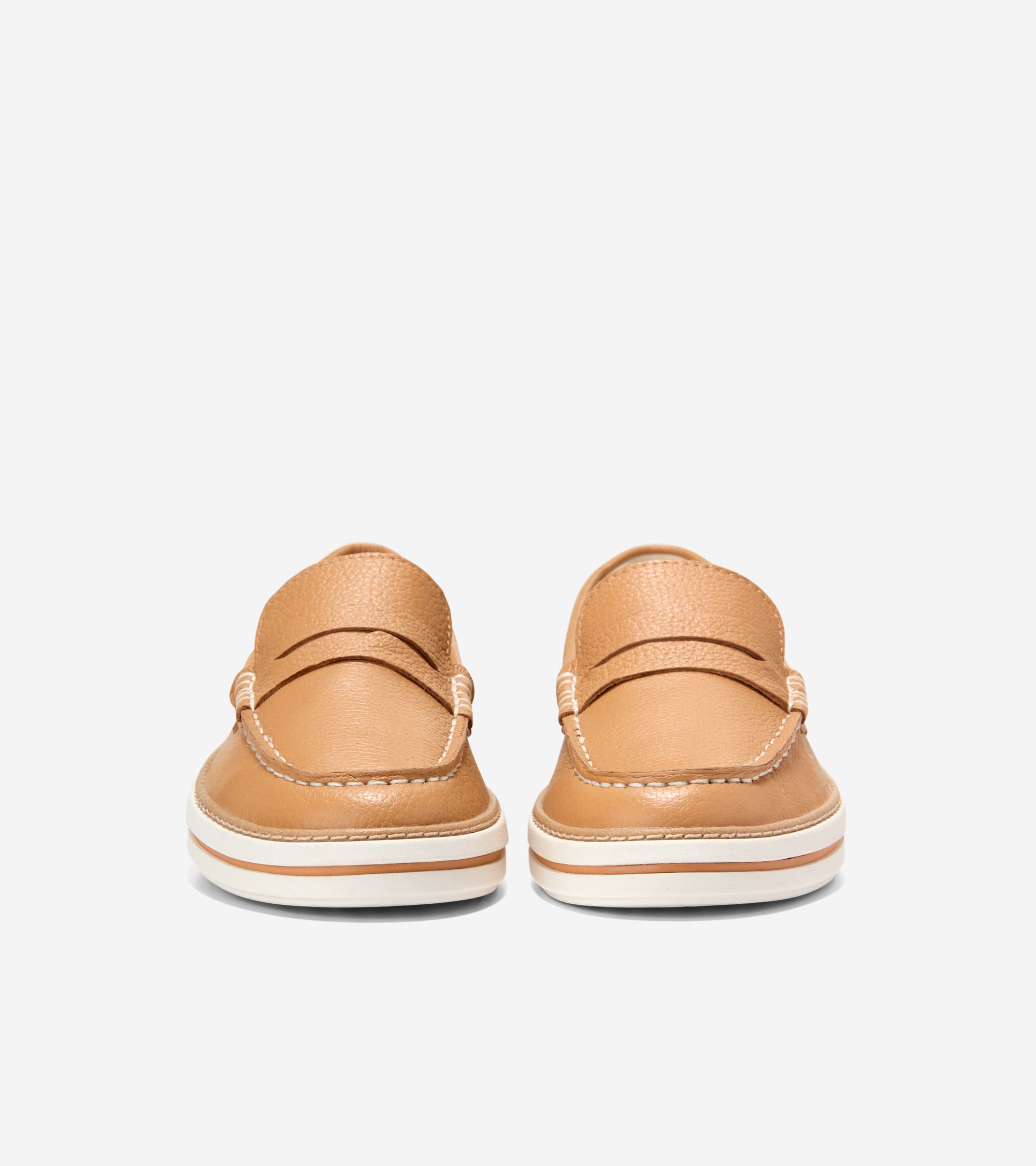 Pair of tan leather penny loafers with white contrast stitching and white soles with a thin tan stripe.