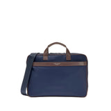 Navy blue slim briefcase with brown leather trim, top handles, and a matching navy adjustable crossbody strap.
