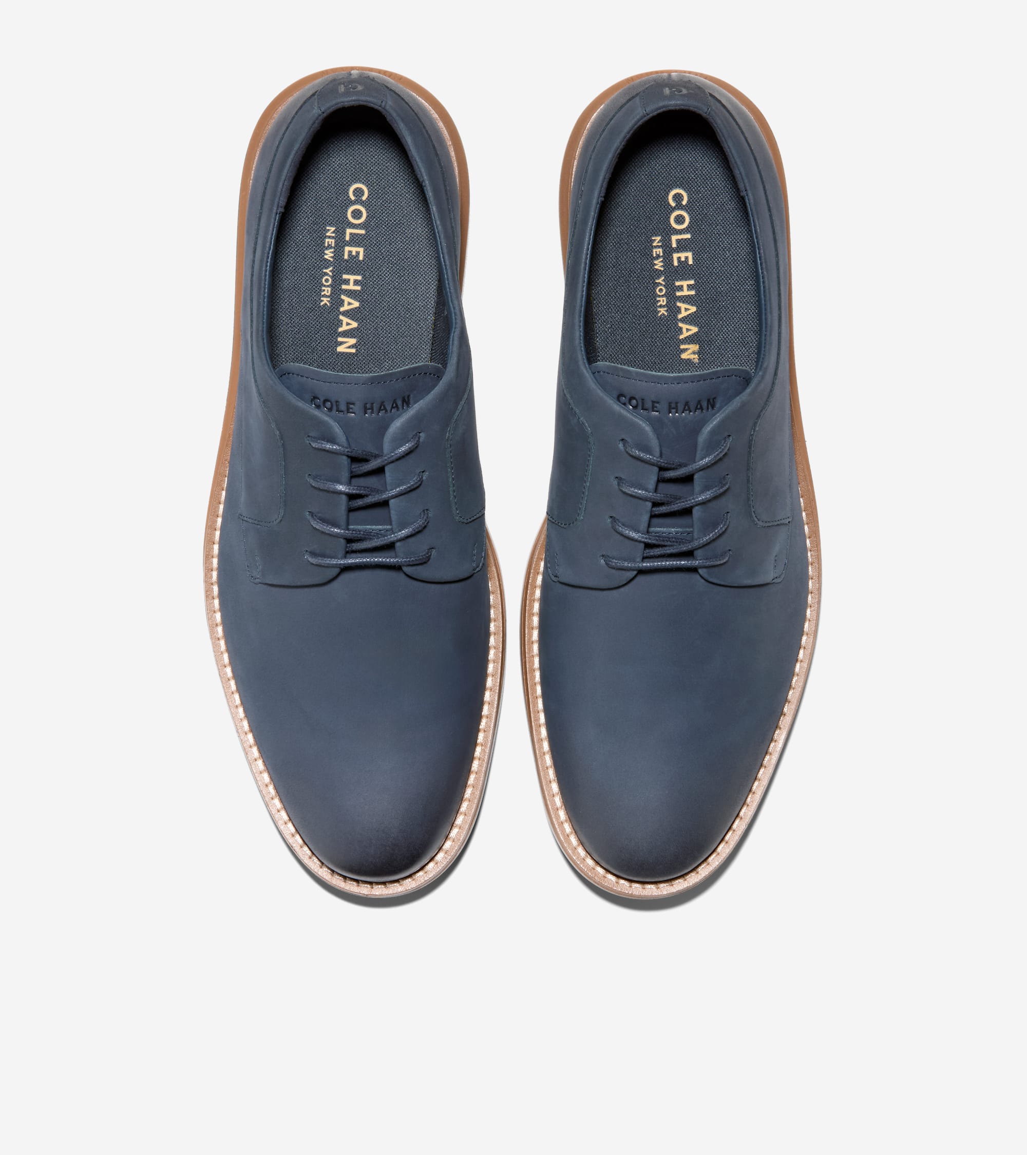 Pair of matte dark blue plain toe oxfords with matching laces, light brown stitched welt, and dark brown outsoles.