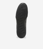 Bottom view of a black sneaker sole with a diamond-patterned tread. 'COLE HAAN GRAND 360' is embossed on the heel.