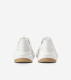 Back view of white leather sneakers with thick white soles and tan bottoms. Embossed 'CH' logo on heels, 'COLE HAAN' text on