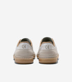 Pair of off-white sneakers with tan trim, suede heel panels, and gum soles. "CH" logo on heel, "COLE HAAN" on sole.
