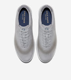 Pair of light gray lace-up sneakers with laser-cut perforations on the toe and sides, white soles, and a dark gray collar tri