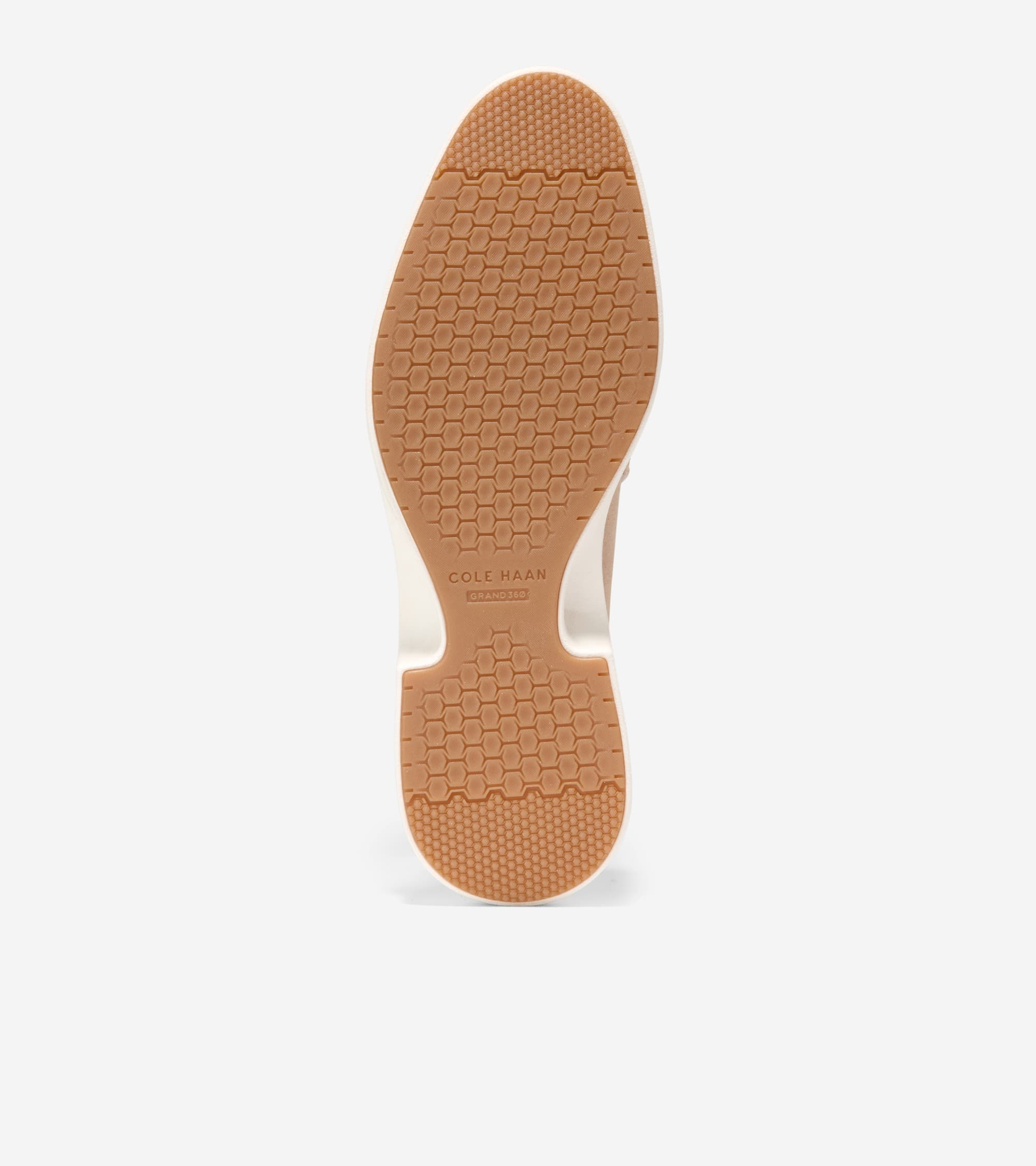 Bottom view of a shoe with a tan rubber sole featuring a hexagonal grip pattern and white midsole. 'COLE HAAN GRAND 360' is e