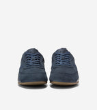 Dark blue suede low-top sneakers with matching laces and light brown rubber soles.