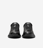 Pair of black leather slip-on sneakers with black laces, chunky black soles, and a silver-toned G logo on each tongue.