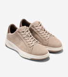 Pair of light tan suede low-top sneakers with white laces, brown heel collar lining, and white soles with tan outsoles.