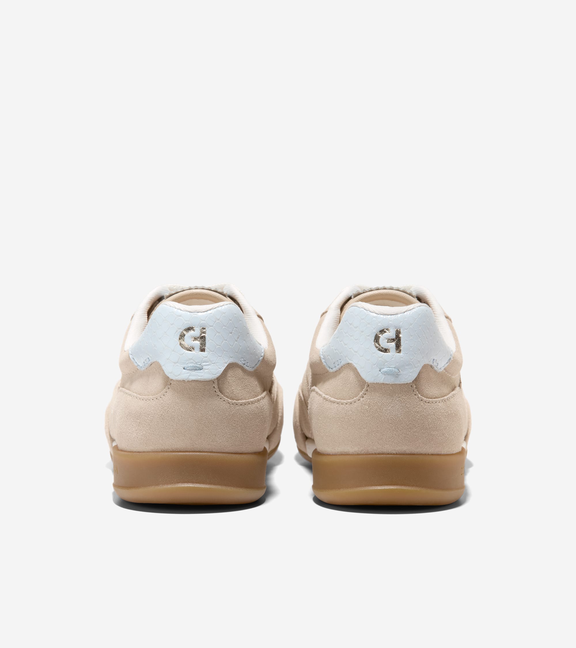 Pair of beige suede low-top sneakers with light blue, textured heel tabs featuring gold-toned 'CH' logos and brown rubber sol