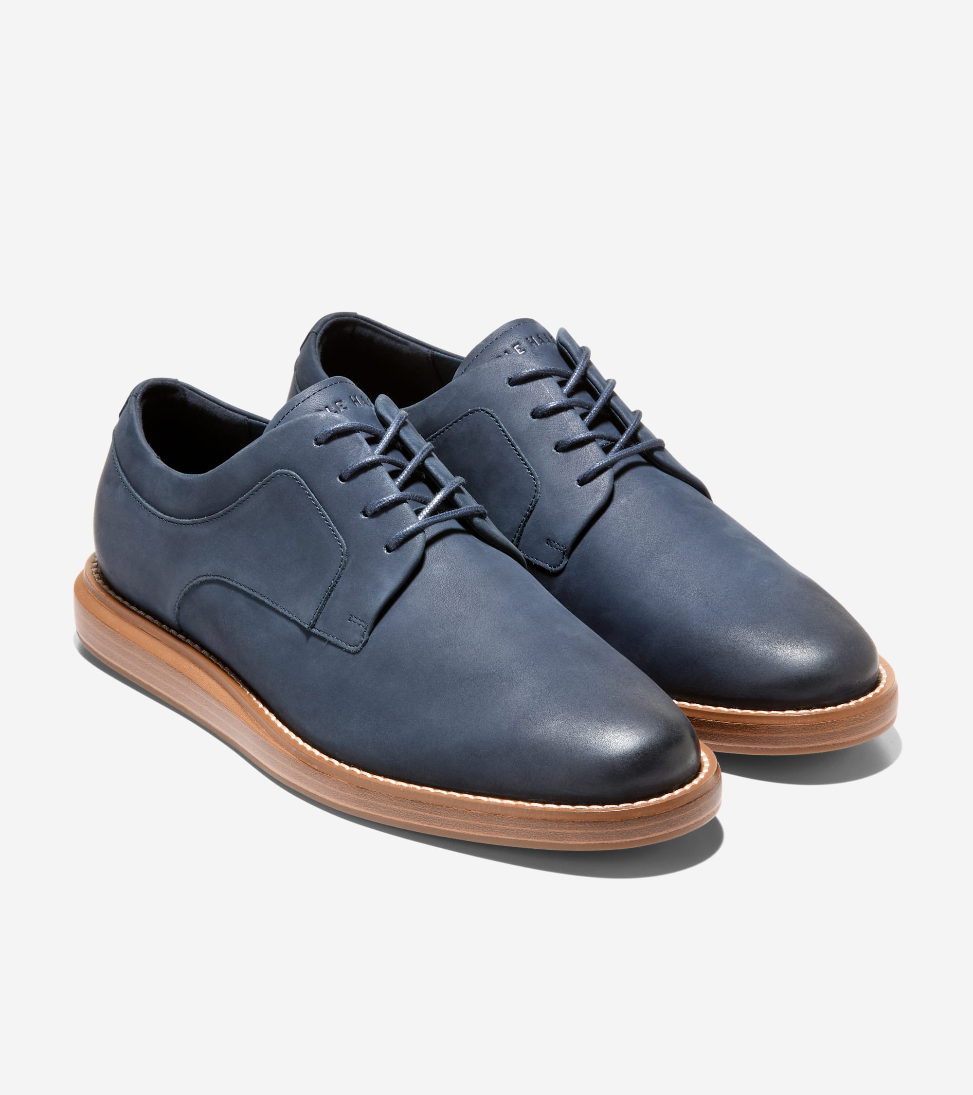 Dark blue matte leather plain toe oxfords with matching laces and a light brown sole with a dark brown top edge.