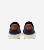 Pair of navy knit slip-on sneakers with brown heel patches featuring a "CH" logo and off-white soles.