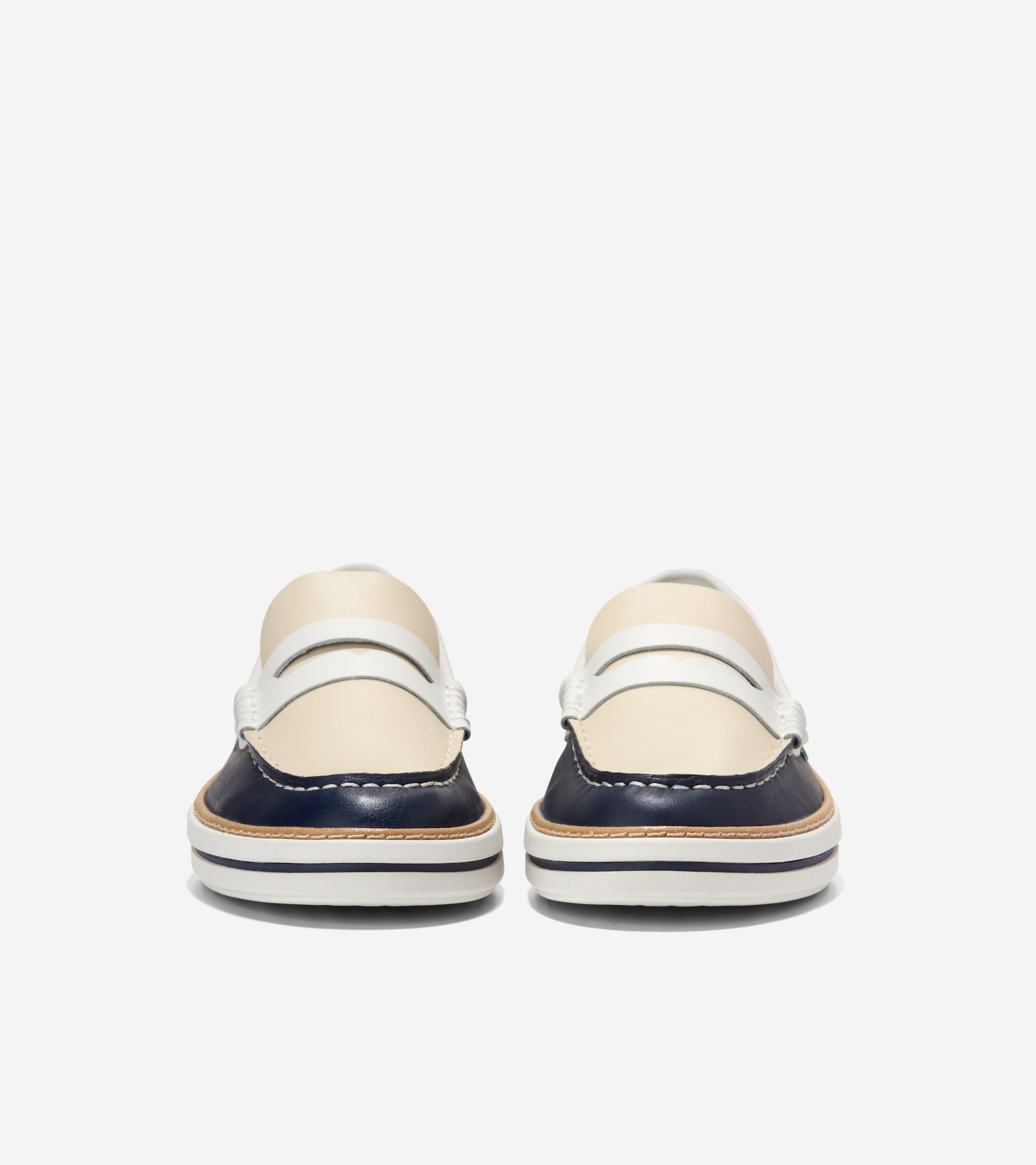 Pair of navy and cream leather penny loafers. White saddle strap over cream vamp, white toe stitching, and layered sole with