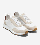 White leather slip-on sneakers with light beige suede overlays, elasticized white laces, brown heel collars, and brown rubber