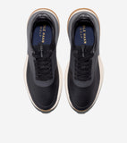 Black golf shoes with textured uppers, black laces, cream midsoles, and tan outsoles. Dark blue insoles with 'COLE HAAN GOLF'