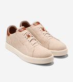 Pair of light beige knitted sneakers with cream soles, brown leather-like accents, and matching laces. Cole Haan logo on side