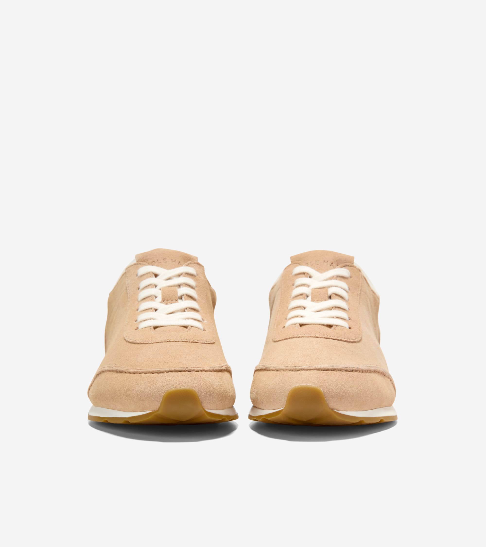 Light tan suede low-profile sneakers with white laces, white midsoles, and brown gum outsoles.