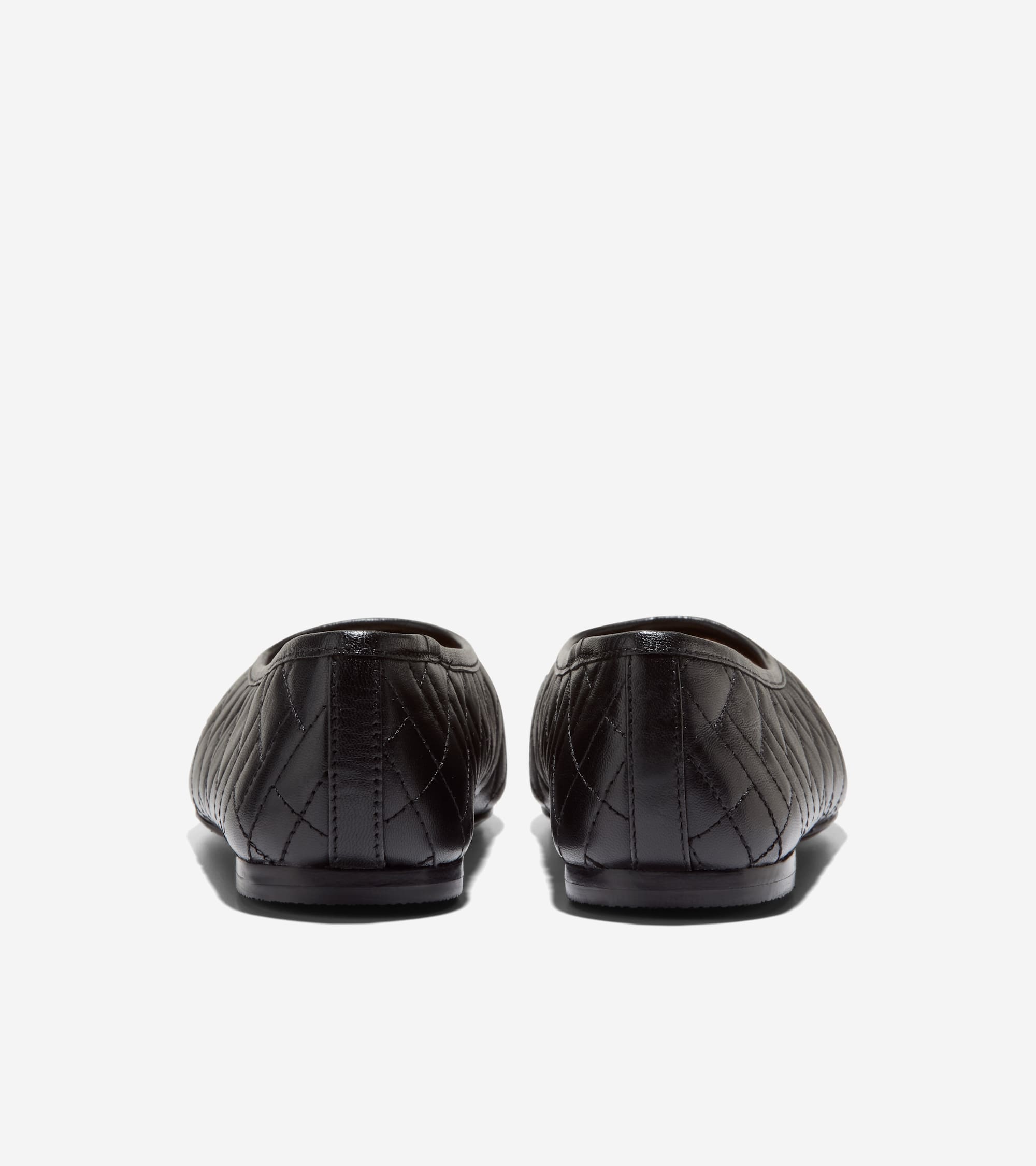 Pair of black quilted ballet flats, seen from the back. They feature a diamond pattern and thin black soles.