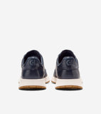 Pair of navy leather slip-on sneakers with thick off-white midsoles and brown outsoles, featuring an embossed 'C' logo on eac